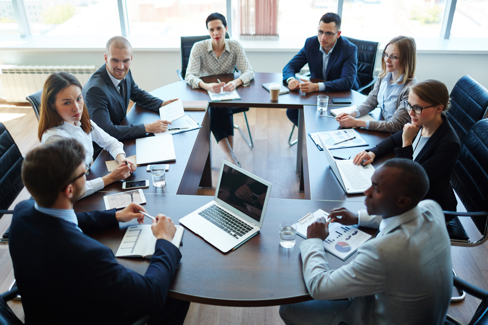 Group of professionals discussing AI-driven video creation tools during a business meeting, showcasing collaboration and technological innovation in video production.