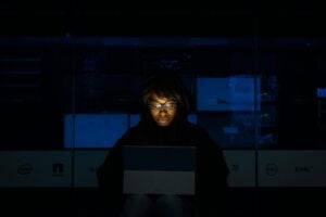 woman wearing black hoodie jacket holding grey laptop computer